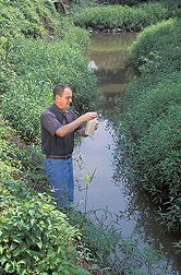 Soil scientist handles a water sample: Click here for full photo caption.