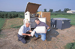 Agricultural engineer and soil scientist collect runoff water samples: Click here for full photo caption.
