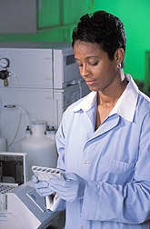 Technician analyzes drainage water samples: Click here for full photo caption.