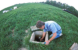 Soil scientist collects a water sample for carbon analysis: Click here for full photo caption.