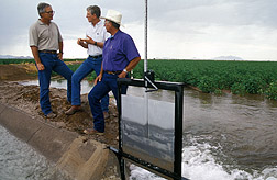 Scientists discuss the flow rate for irrigating this field. Click here for full photo caption.
