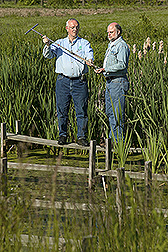 Soil scientist and Ohio State University extension agricultural engineer discuss features and treatment efficiency of a constructed wetland: Click here for full photo caption.