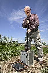 Soil scientist moves a flashboard riser in a drainage water management structure: Click here for full photo caption.