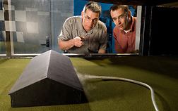 To better interpret airflow patterns around physical structures, plant physiologist (left) and soil scientist use smoke to help them observe airflow patterns inside the wind tunnel: Click here for full photo caption.