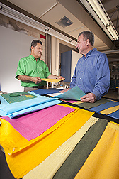 Technician (left) and textile chemist discuss new uses for the colorful cotton-based nonwoven fabrics they dyed and finished in the wet-finishing laboratory: Click here for full photo caption.