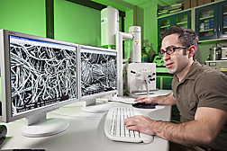 Postdoctoral research associate compares the structure of nonwoven (left) and woven (right) cotton fabrics using a scanning electron microscope: Click here for full photo caption.