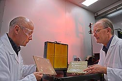 Food technologist Artur Klamczynski (left) and plant physiologist Greg Glenn prepare to use an infrared heater, located behind them, to conduct burn tests of siding coated with experimental fire-retardant gel: Click here for full photo caption.