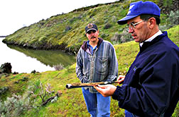 Oregon wetland resource manager Cody Johnson (left) examines a soil core drawn by ARS agricultural engineer Dale Wilkins