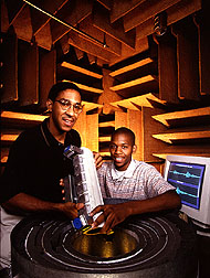 Everett Foreman (left) and student insert an insect detection device into a portable, sound-insulated enclosure. 
