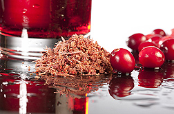 Photo: A glass of cranberry juice, whole cranberries and a pile of cranberry pomace on a table. Link to photo information