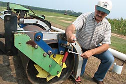 Agricultural engineer Ted Kornecki adjusts the crimping force of his patented smooth roller with oscillating crimping bar: Click here for photo caption.