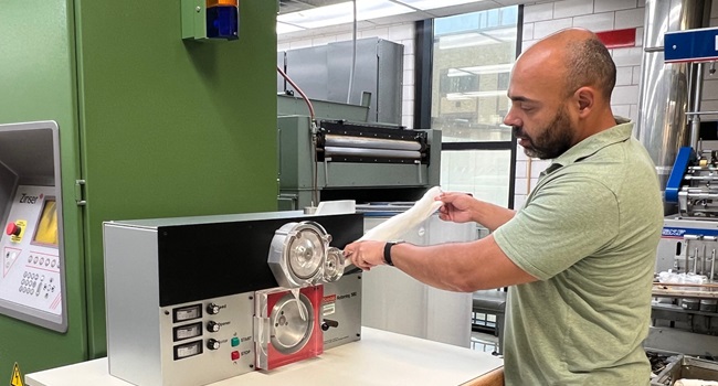 USDA Research Chemist Michael Santiago is loading a cotton sliver sample into a Spinlab Rotorring 580 to measure the frictional characteristics of the fibers.  This is part of a larger study to determine how fiber friction impacts the energy required to produce cotton products.