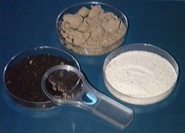 Images of samples of sand, clay, loam(potting soil), and a magnifying glass