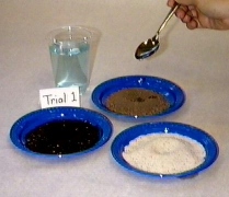Image of three soil type samples on plates with water being added into depressions