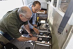 USDA scientists installing digital cameras in a small airplane.