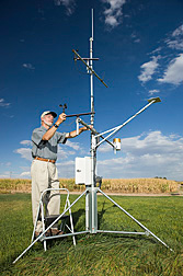 Photo: Agricultural engineer Tom Trout checks instruments on a weather station that predicts water consumption. Link to photo information