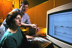 Geneticists Lynn Senior and John LeDeaux enter genetic test results into a computer database for statistical analyses.