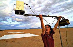 ARS scientist Susan Moran adjusts a fixed position four-camera monitoring device to take soil readings.
