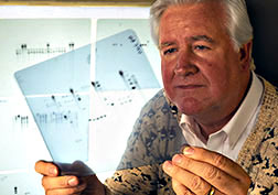 Cytogeneticist Ron Philips examines a radiogram from DNA hybridization techniques.