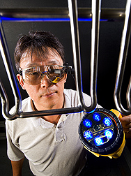 Scientist Moon Kim wearing a tiny head-mounted display monitor resembling a pair of safety glasses. Link to photo information