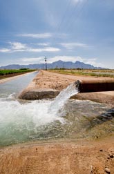 Photo: Water flowing from a pipe into an irrigation canal. Link to photo information