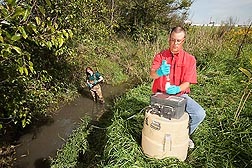 Photo: ARS soil scientist tests stream bed sediments. Link to photo information
