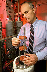 Chemist Jerry King inserts ground beef patties into a high-pressure extraction vessel. Click here for full photo caption.