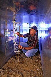 Agricultural engineer Keith Saxton adjusts wind measuring devices inside a portable, 45-foot wind tunnel. 