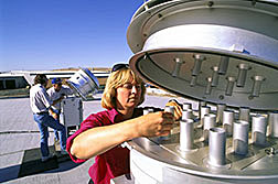 Meteorologist Mary Hattendorf changes a 10-micron filter on a high-volume dust sampler.