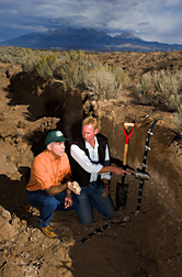 Near a potato field, Jorge Delgado and Alan Stuebe kneel to study a 4-foot-deep area of soil exposed by a trench. Link to photo information