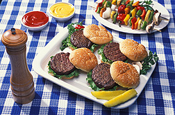 Photo: Four hamburgers on a white plate on a table. Link to photo information