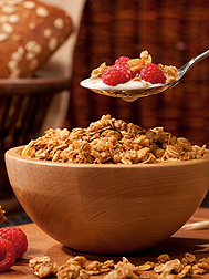 Photo: A spoon of cereal, raspberries and milk is being held above a bowl of cereal. Link to photo information