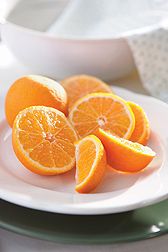 Photo: Sliced mandarin oranges next to a photo of vials of mandarin orange juice.