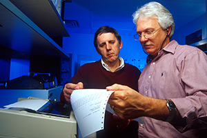 Don Knowles and microbiologist Willard Goff examine data from an automated spectrometer