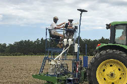 Tractor planter and operators planting soybean seed