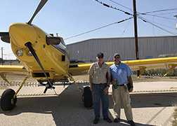 ARS researcher and a pilot standing in front of a small plane