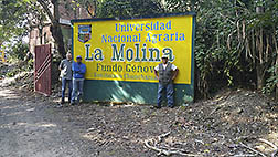 Three scientists standing in front of a sign for a research station in Peru