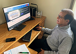 Vijay Juneja sitting in front of a computer using ComBase