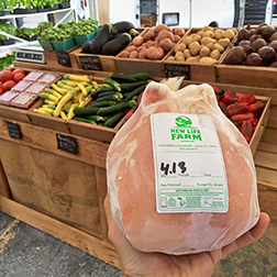 A packaged chicken for sale at a farm