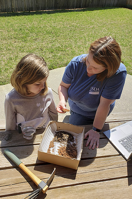 Mother and daughter perform a science activity involving erosion by water