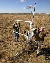 Jim Bradford and Phillip Sims adjust a weather station fitted with instruments that measure carbon cycling. Link to photo information