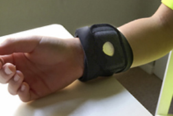 Wireless sensor worn on wrist of child to measure emotional fluctuations through monitoring sweat gland activity. Link to photo information